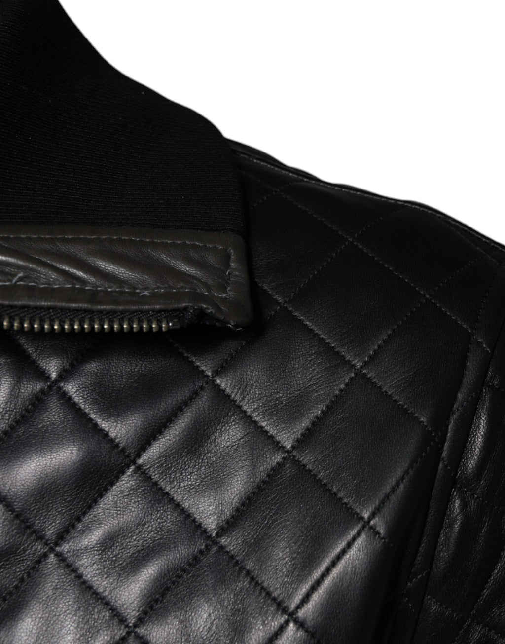 Veste noire en cuir de veau matelassé avec fermeture éclair complète, conçue par Dolce & Gabbana, visible sur l'image.