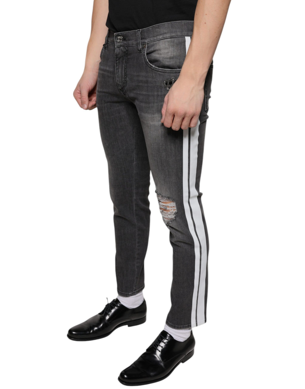 Jeans homme en denim noir skinny tâté de coton Dolce & Gabbana, style déchiré et ajusté, visible en gros plan.