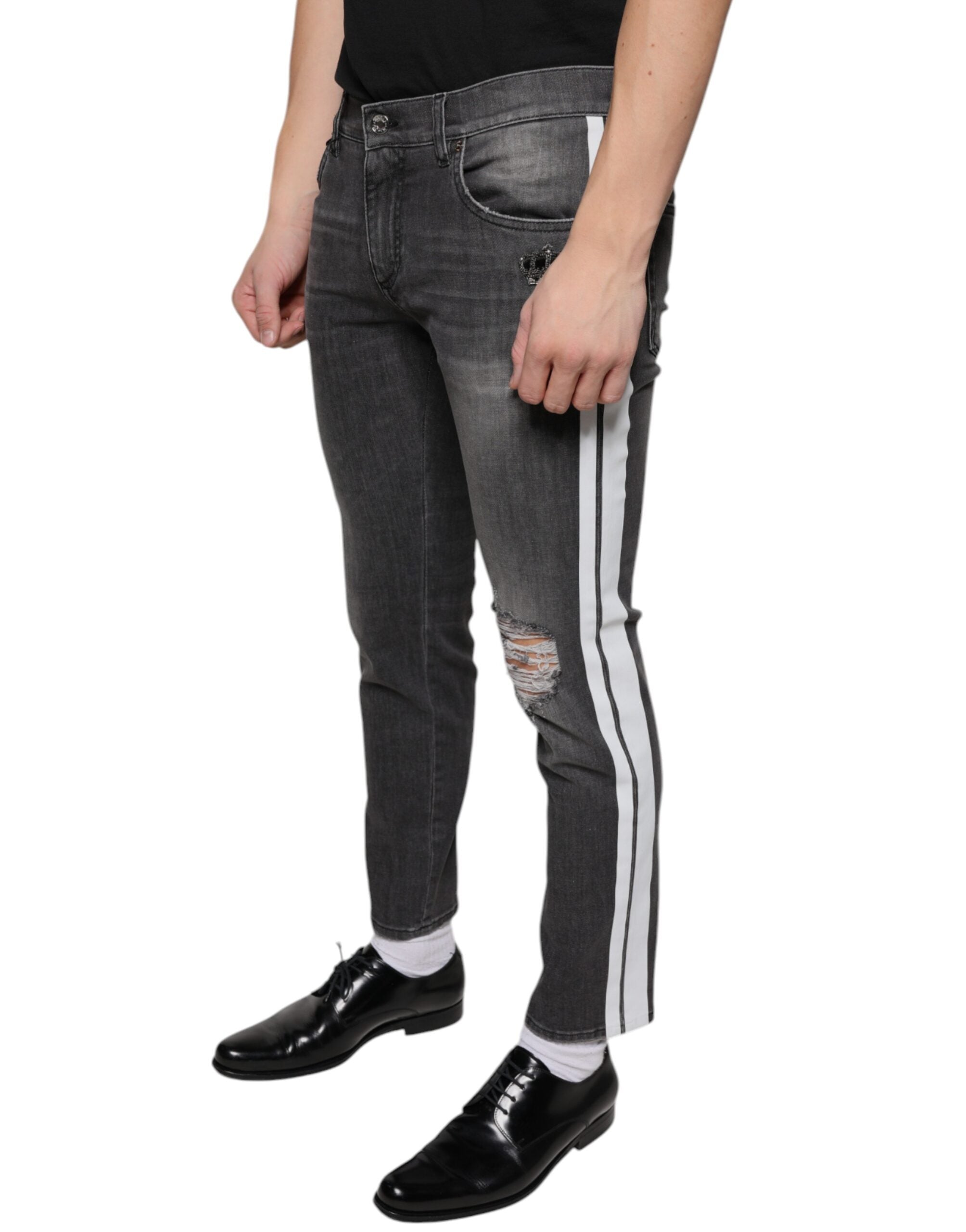 Jeans homme en denim noir skinny tâté de coton Dolce & Gabbana, style déchiré et ajusté, visible en gros plan.
