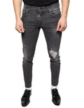 Jeans slim en coton déchiré noir de Dolce & Gabbana pour homme, style skinny avec détails usés et déchirés.