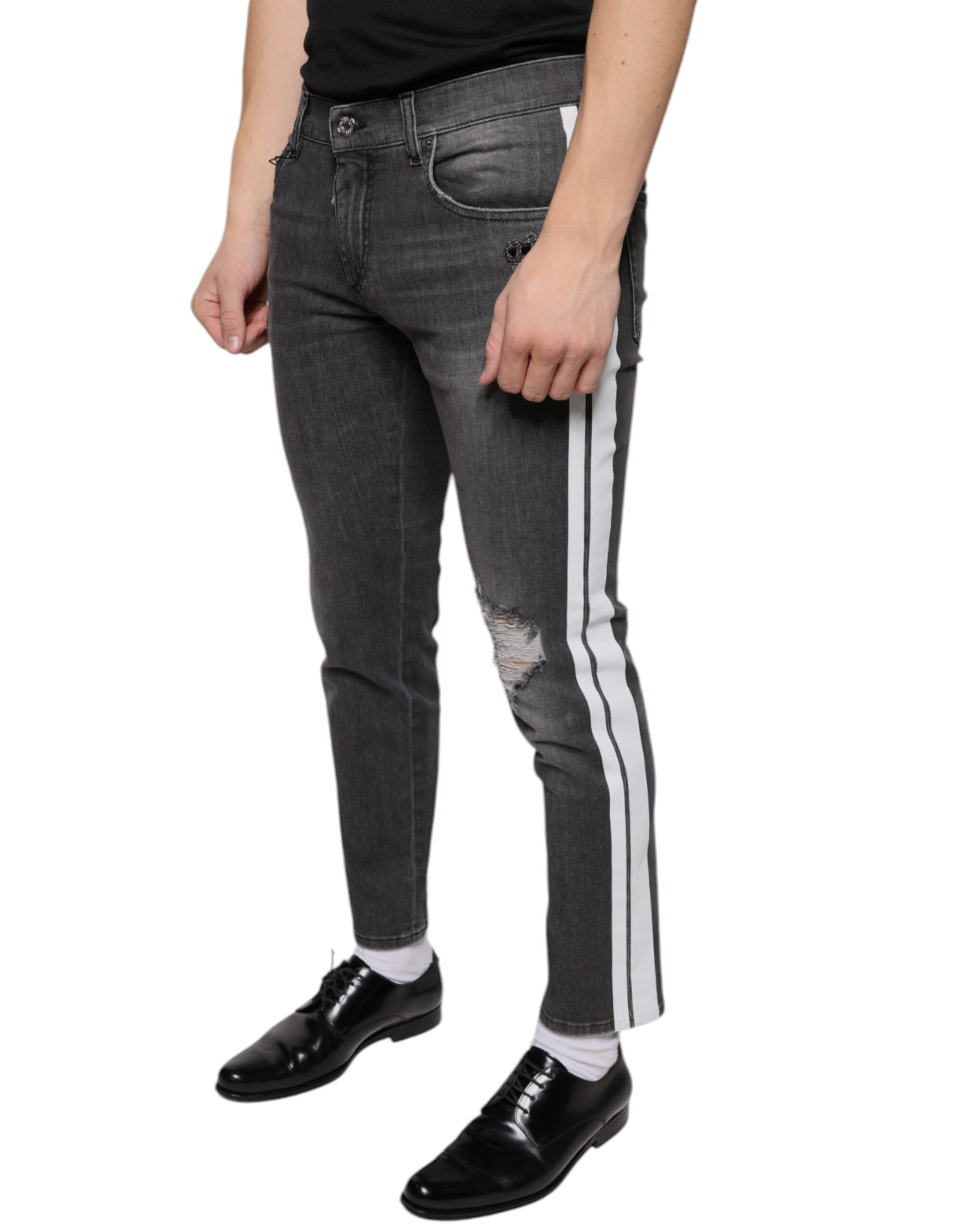 Jeans homme Dolce & Gabbana en denim noir déchiré, coupe skinny, en coton, avec détails usés.