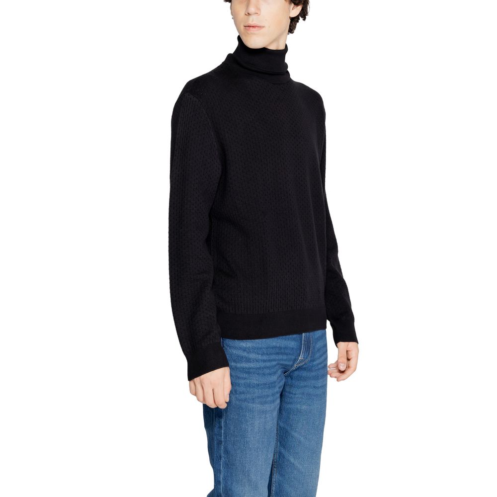 Pull à col roulé en coton noir de la marque Armani Exchange, visible en gros plan.