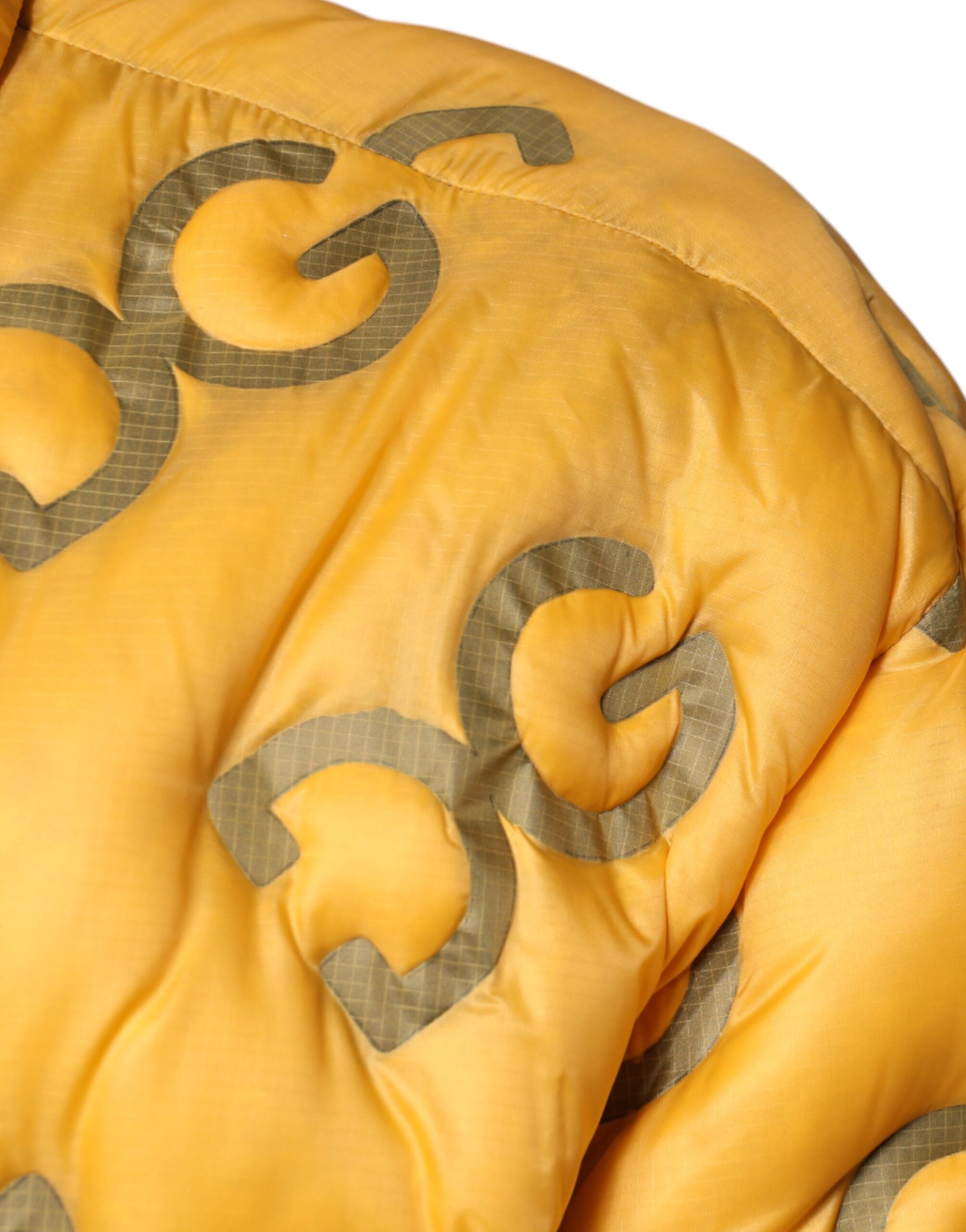 Veste matelassée jaune Dolce & Gabbana avec logo, boutons et col montant, style élégant et moderne.