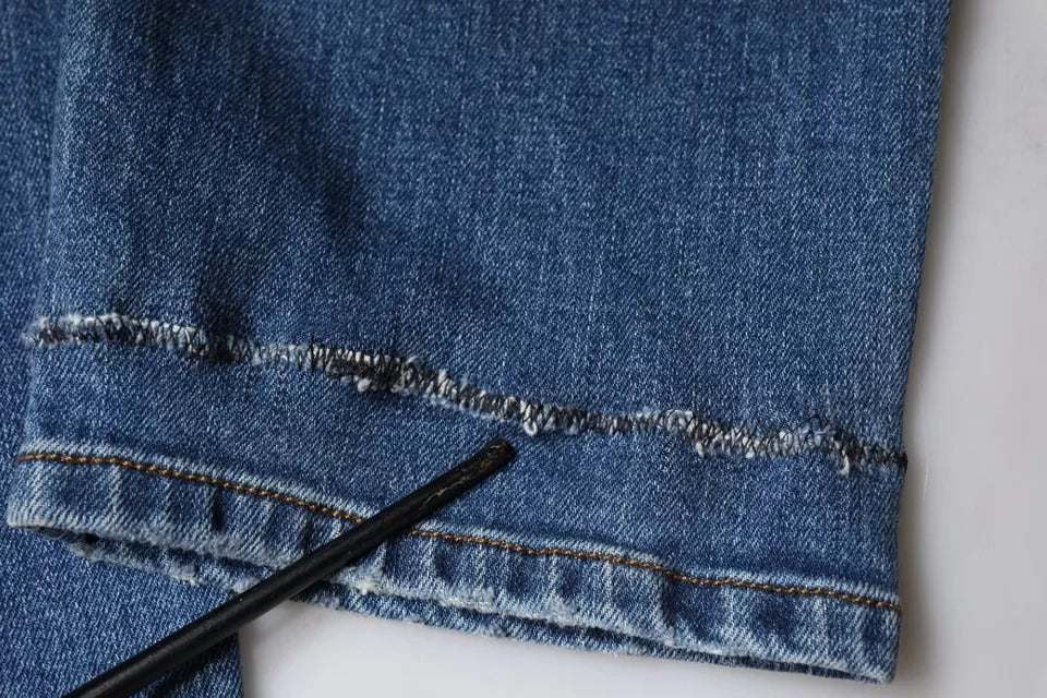 Jeans homme en denim bleu lavé Dolce & Gabbana en coton stretch, ajustés et modernes, visibles en gros plan.