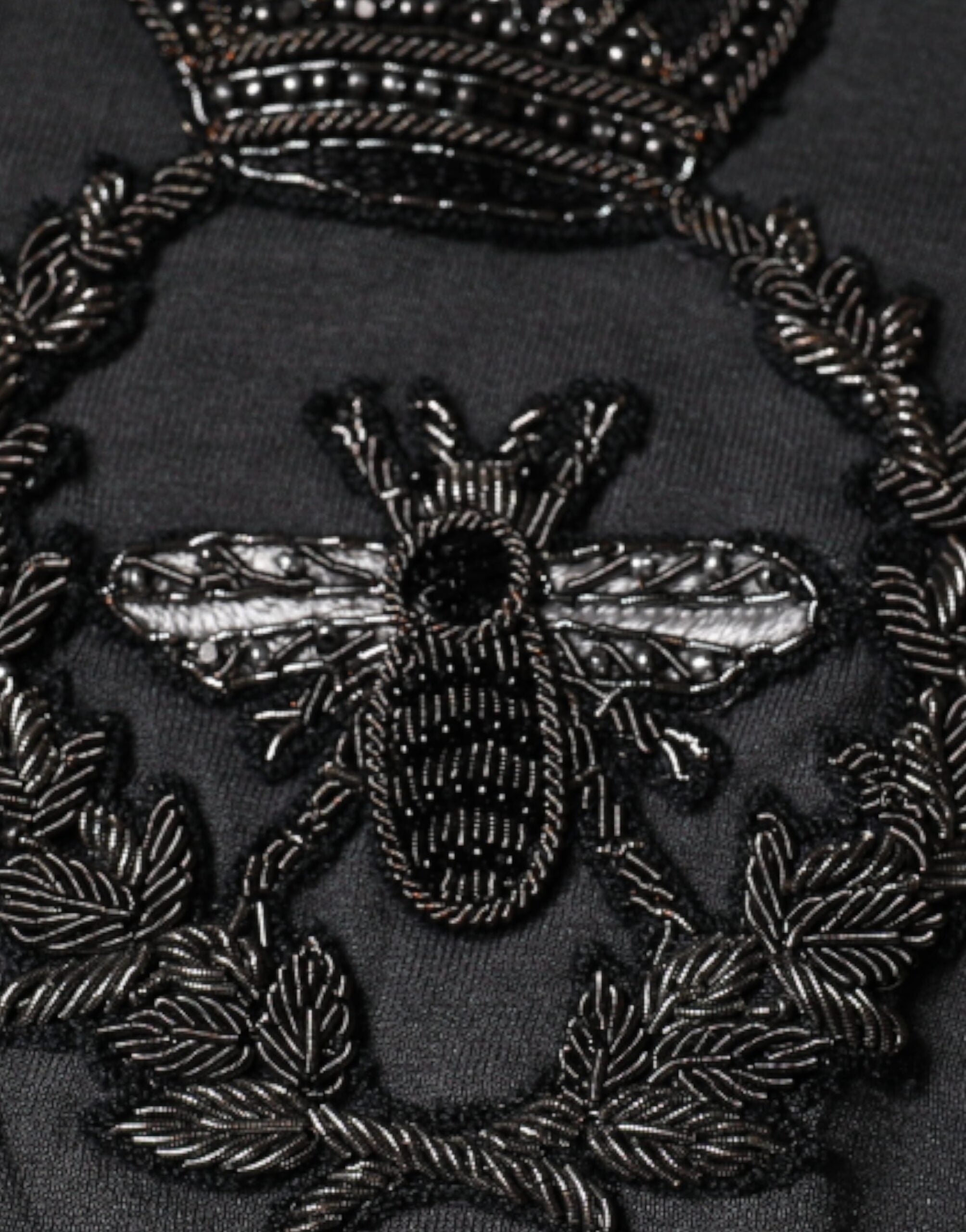 Pull-over Dolce & Gabbana gris avec broderie couronne d'abeille, motif élégant et détails raffinés.