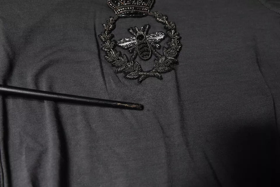 Pull à col rond Dolce & Gabbana gris avec broderie d'une abeille couronne, tissu doux et détails élégants visible sur l'image.