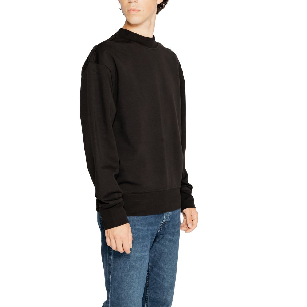 Sweat-shirt noir en coton recyclé de Calvin Klein Jeans, avec logo discret sur la poitrine, porté sur un mannequin.