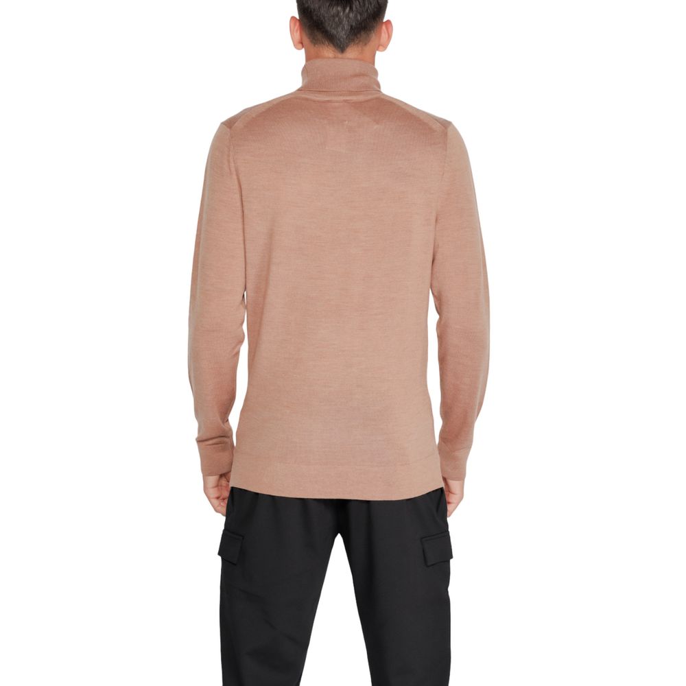 Pull en laine beige Calvin Klein à col roulé, visible avec texture douce et coupe élégante.