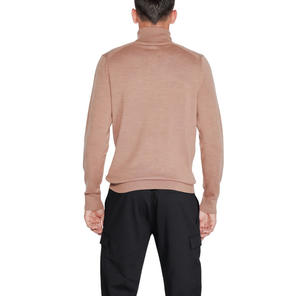 Pull en laine beige Calvin Klein à col roulé, doux et élégant, porté sur un mannequin.