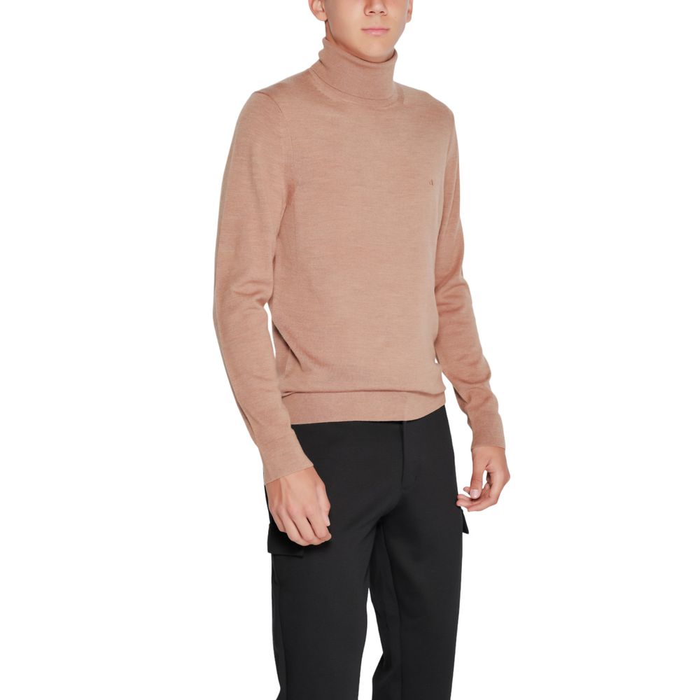 Pull en laine beige Calvin Klein à col roulé, douceur et style sophistiqué, porté en détail dans l'image.
