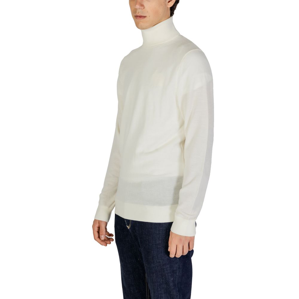 Pull en laine crème Calvin Klein Jeans à col roulé, douceur et style, visible en détail dans l'image.