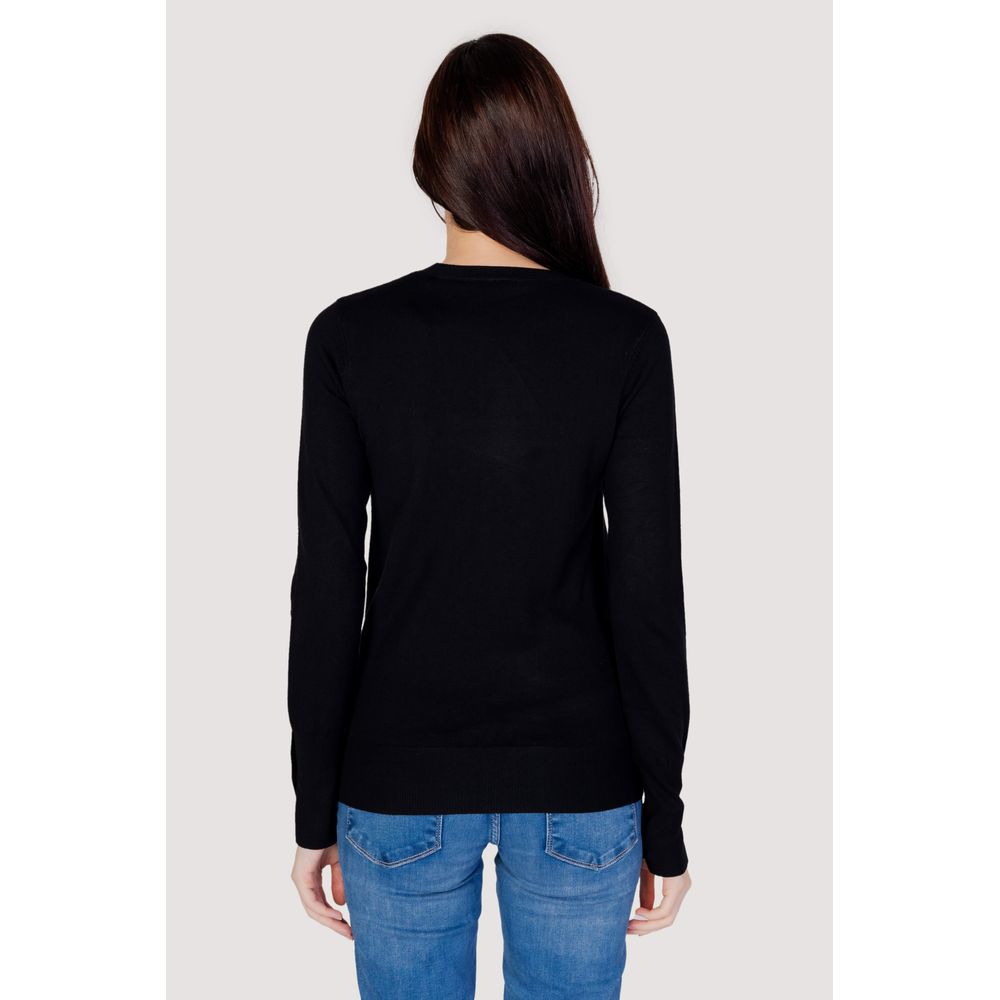Sweatshirt noir en coton de la marque Guess, avec logo discret, porté dans une image de style décontracté.