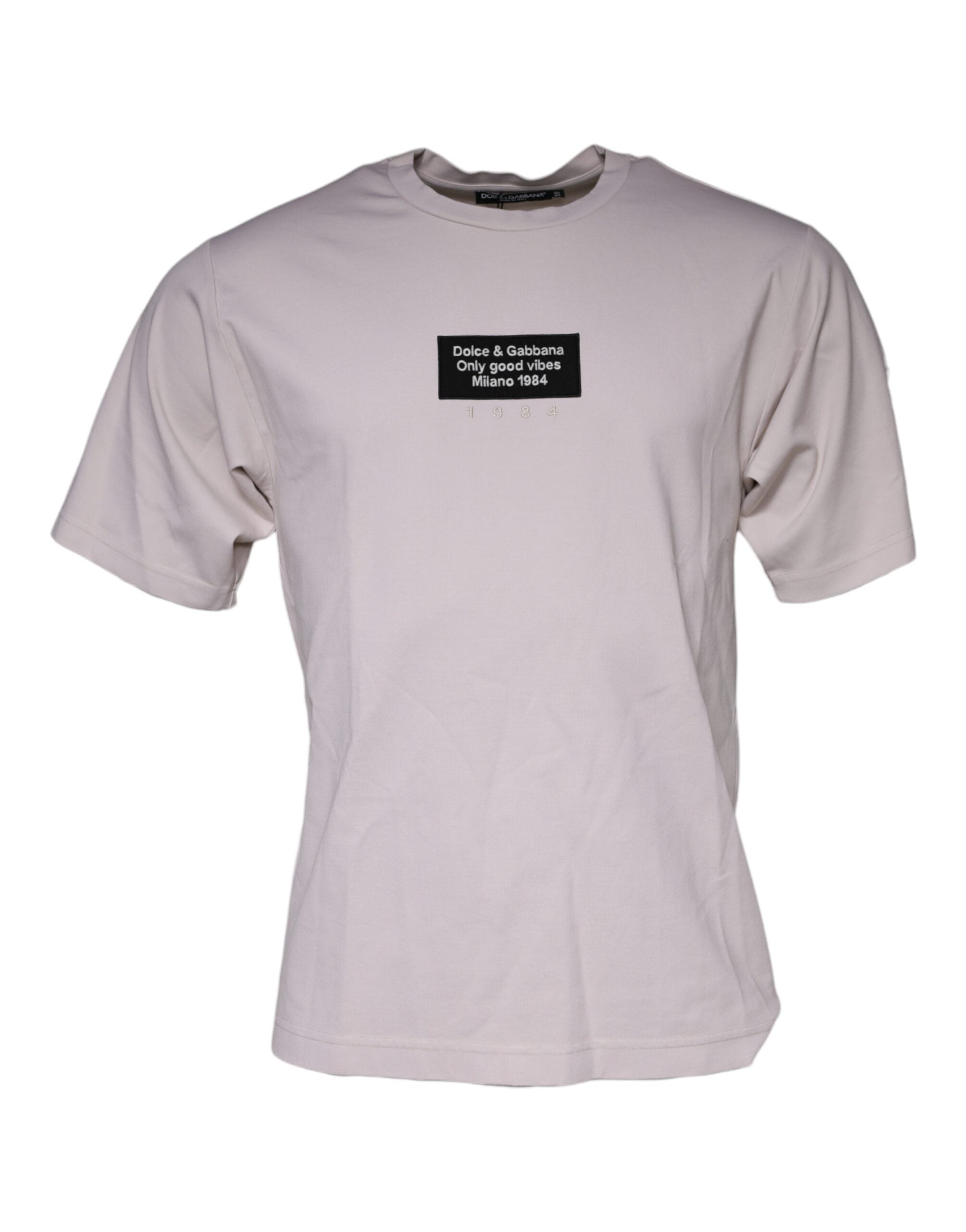 T-shirt beige en coton mélangé Dolce & Gabbana avec logo, col rond, visible sur fond neutre, style décontracté.