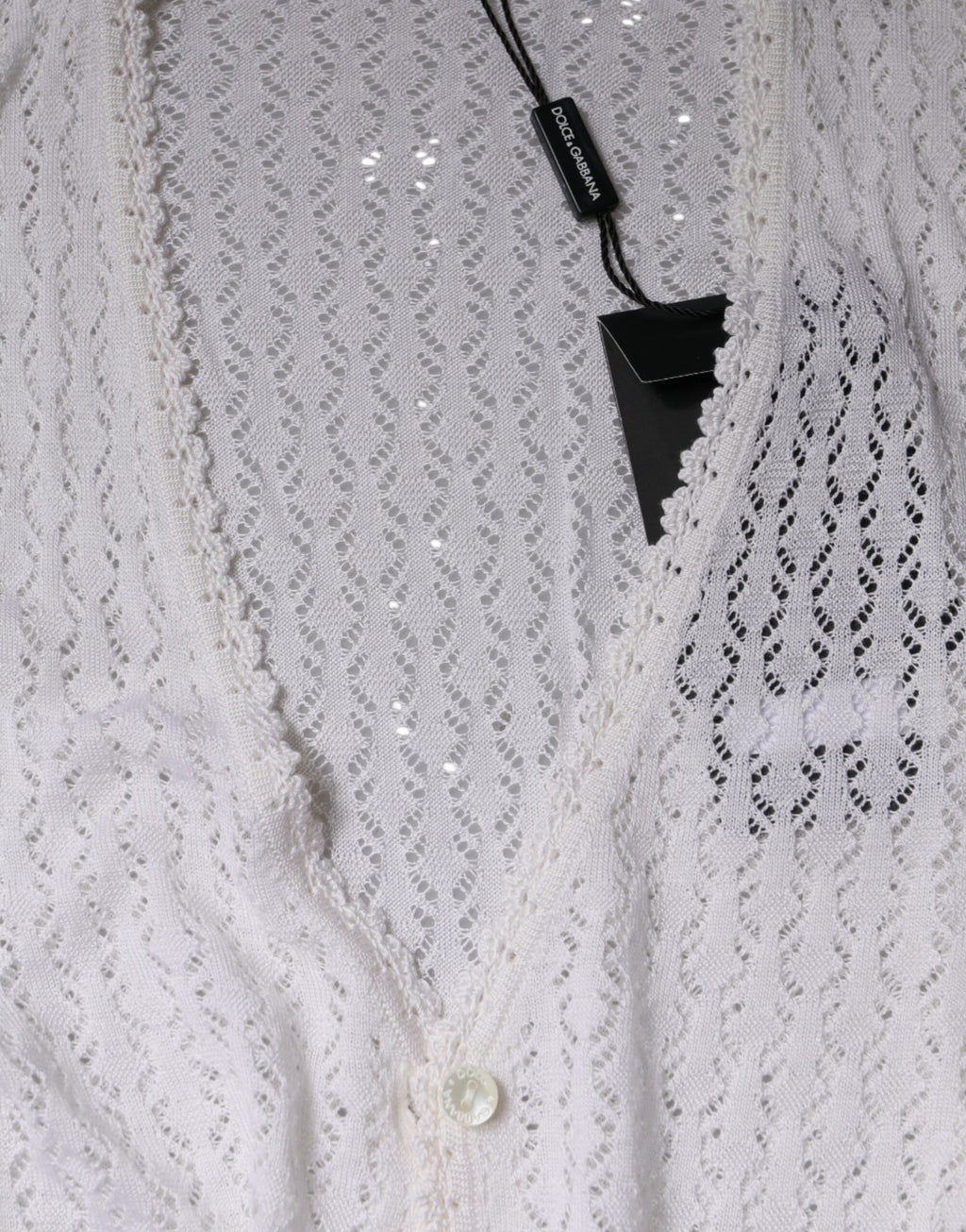 Cardigan blanc en soie Dolce & Gabbana avec boutons, porté sur un mannequin, détails élégants et tissu fluide visible.