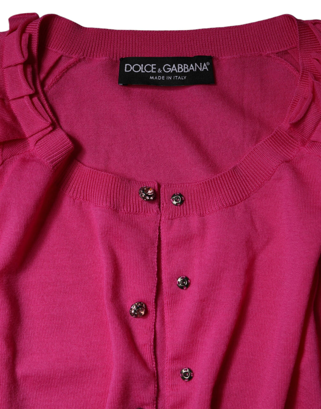 Cardigan Dolce & Gabbana en laine rose avec boutons, vêtement tendance pour femme, détail de la texture et du design.