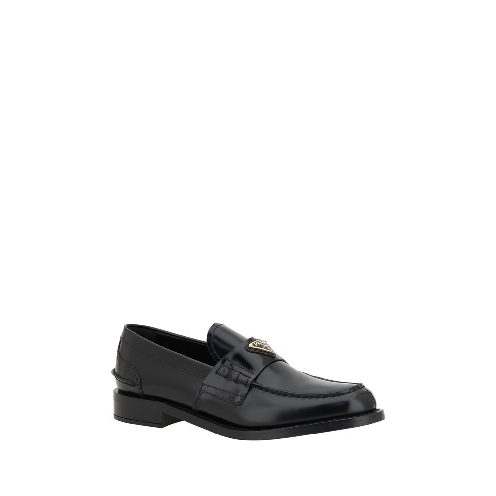 Chaussures mocassins en cuir noir Prada avec logo en relief, élégantes et sophistiquées, pour un style classique et raffiné.