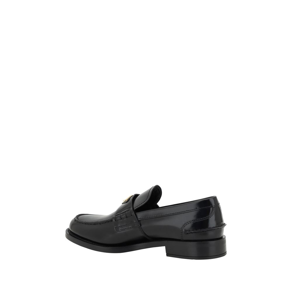 Mocassins en cuir noir Prada avec logo en relief, élégants et confortables, pour un style sophistiqué.