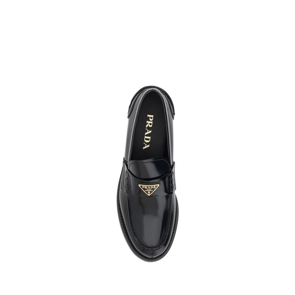 Chaussures mocassins en cuir noir Prada avec logo, vue en gros plan, élégantes et sophistiquées.