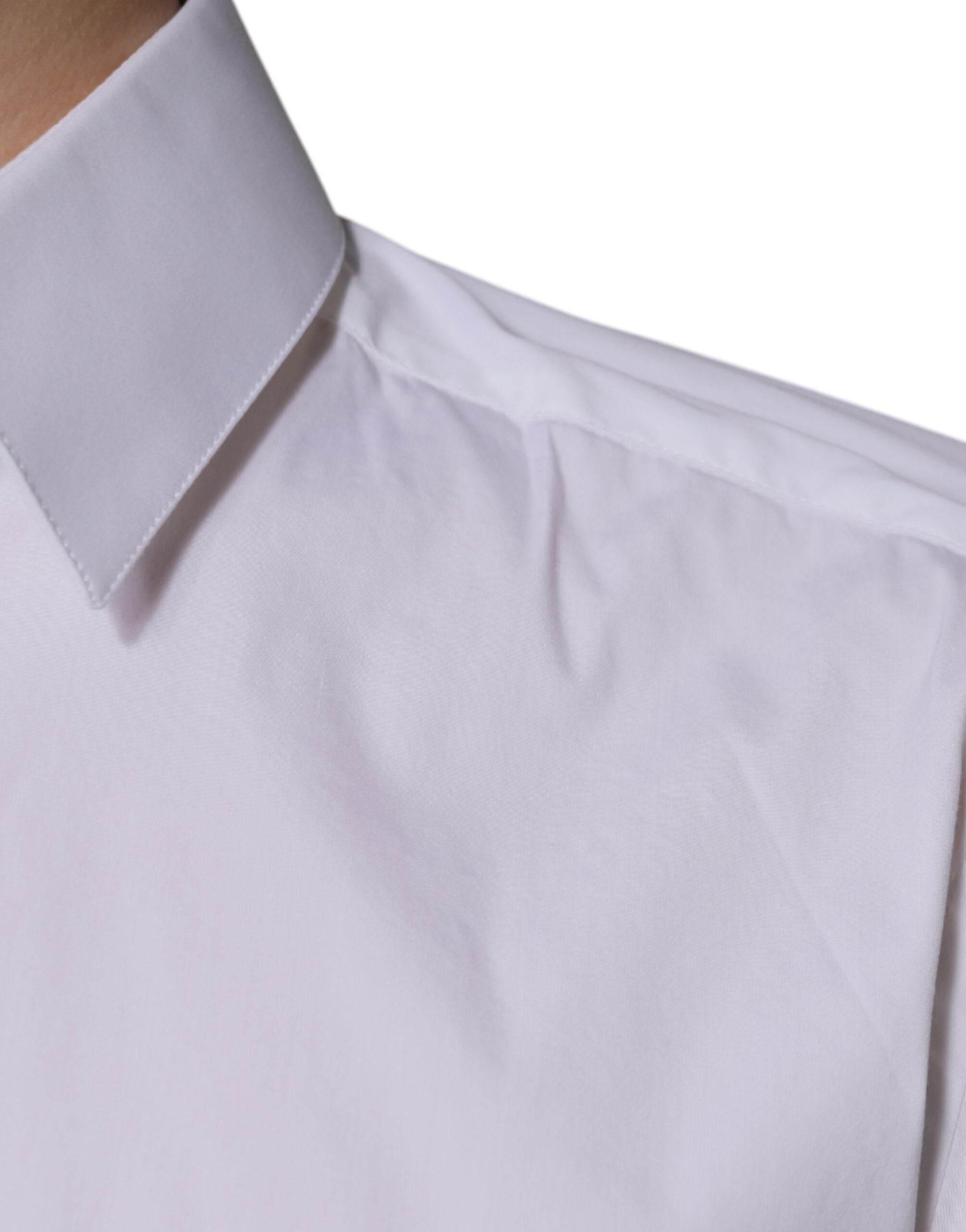 Chemise longue en coton blanc Dolce & Gabbana avec manches longues et détails dorés visibles sur l'image.