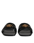 Chaussures plates slip-on en cuir noir Versace avec plaque logo, style élégant et confortable pour homme.