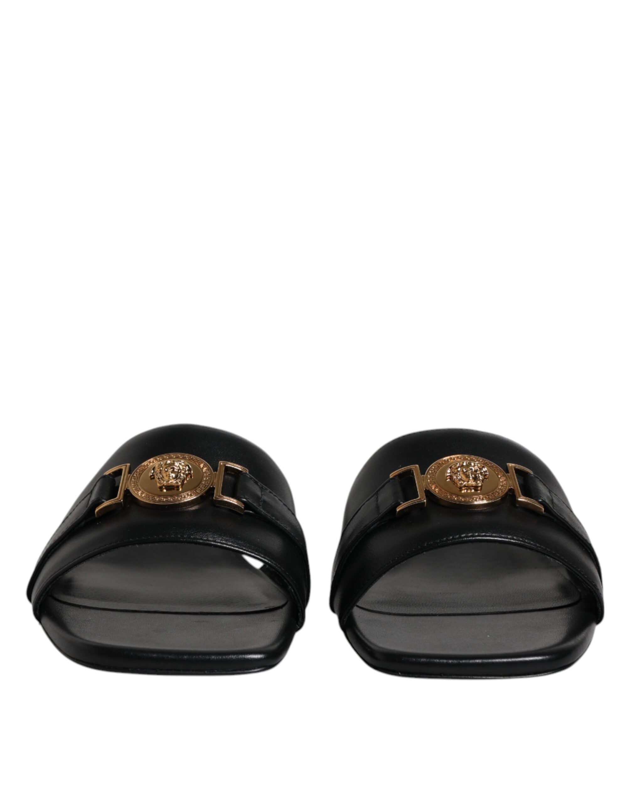Chaussures plates slip-on en cuir noir Versace avec plaque logo, style élégant et confortable pour homme.