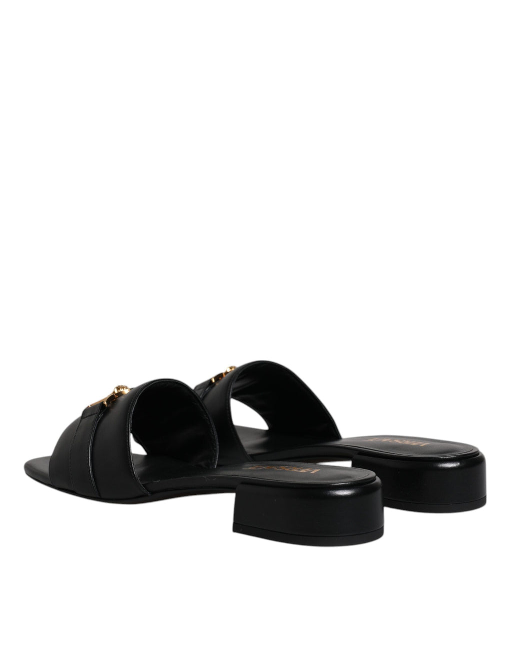 Sandales plates en cuir noir Versace avec plaque logo, style slip-on, chaussures élégantes et confortables.