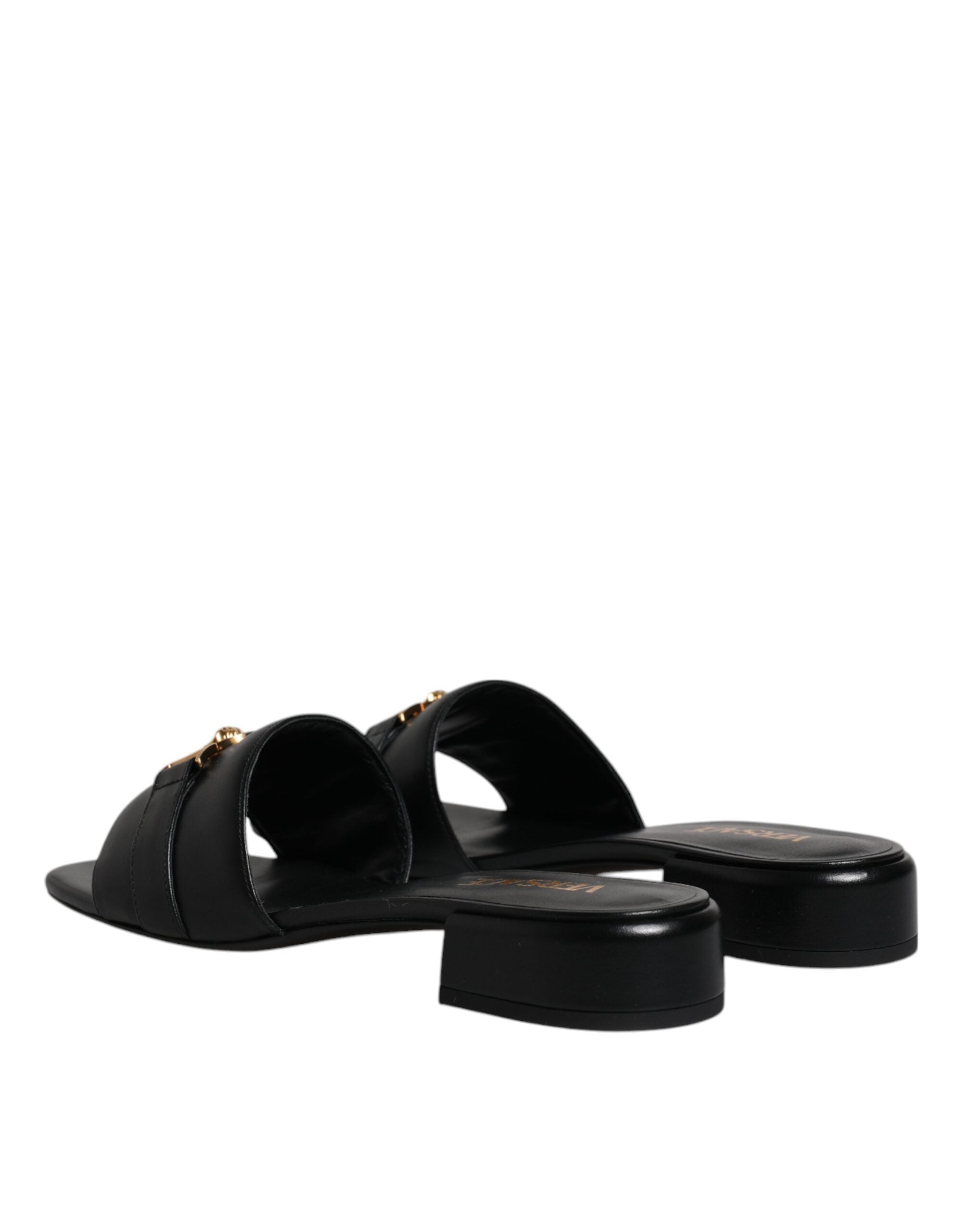 Sandales plates en cuir noir Versace avec plaque logo, style slip-on, chaussures élégantes et confortables.