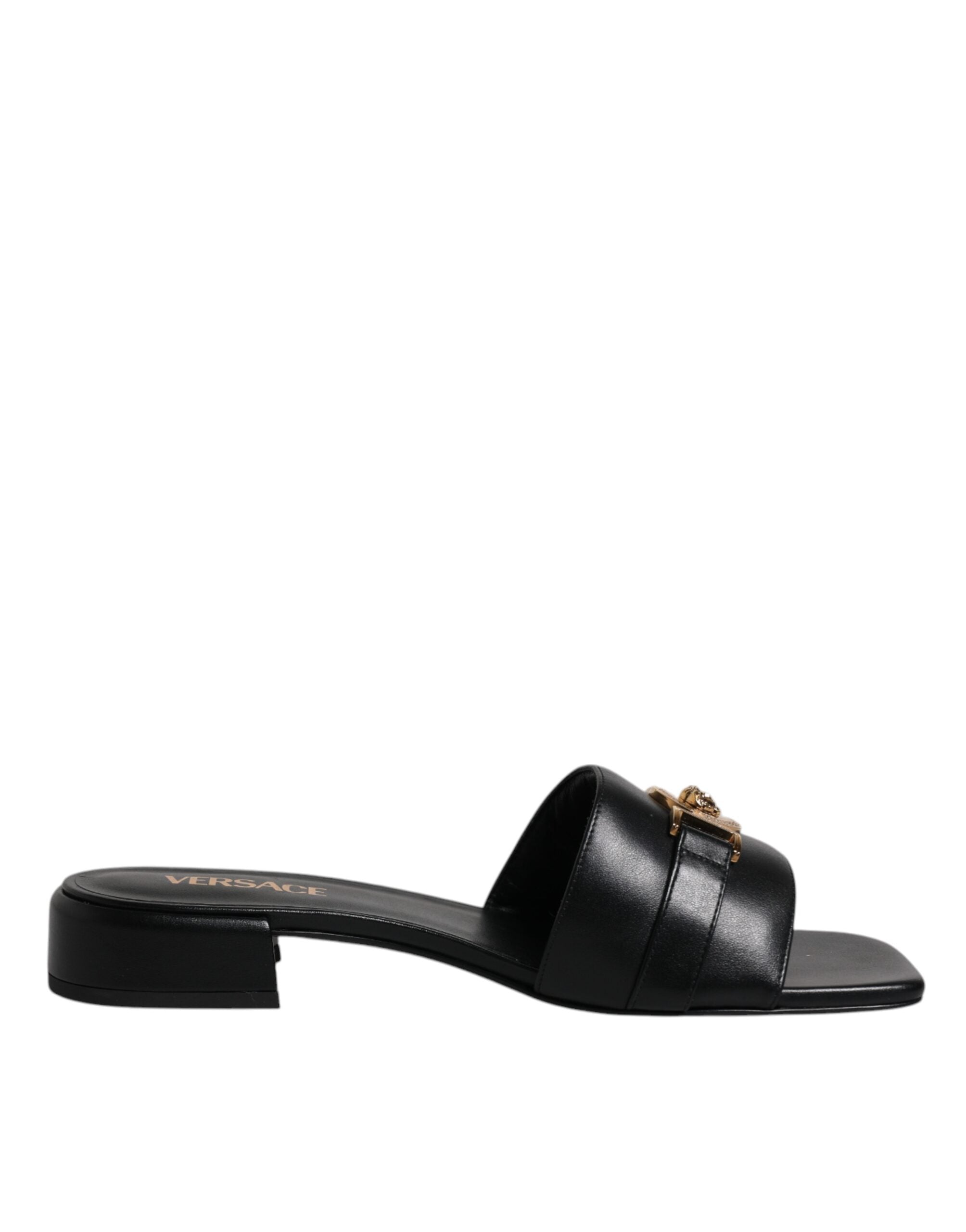 Chaussures plates slip-on Versace en cuir noir avec plaque logo, style élégant et confortable pour homme.