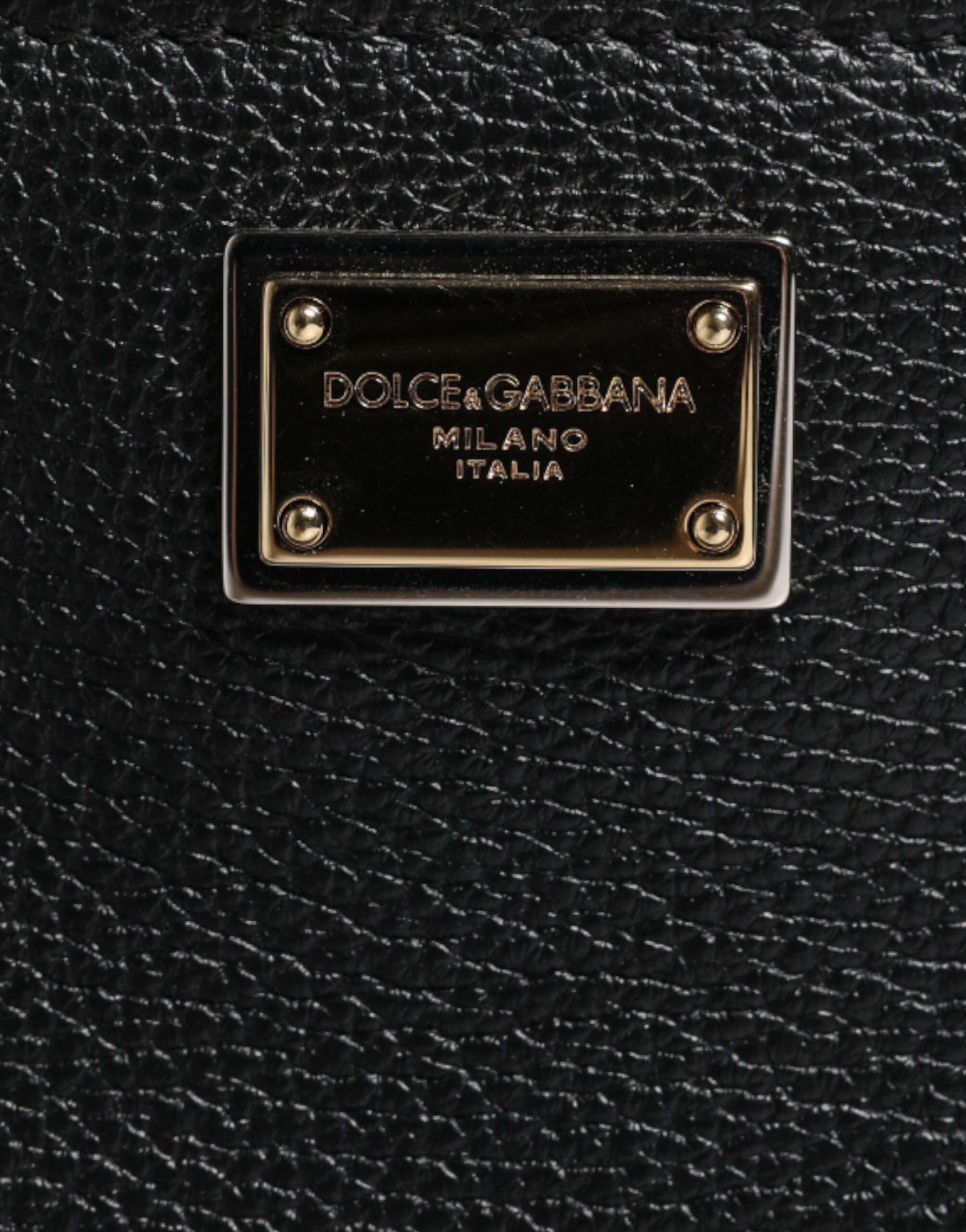 Sac clutch noir en cuir grainé Dolce & Gabbana avec plaque logo élégante, idéal pour une occasion sophistiquée.