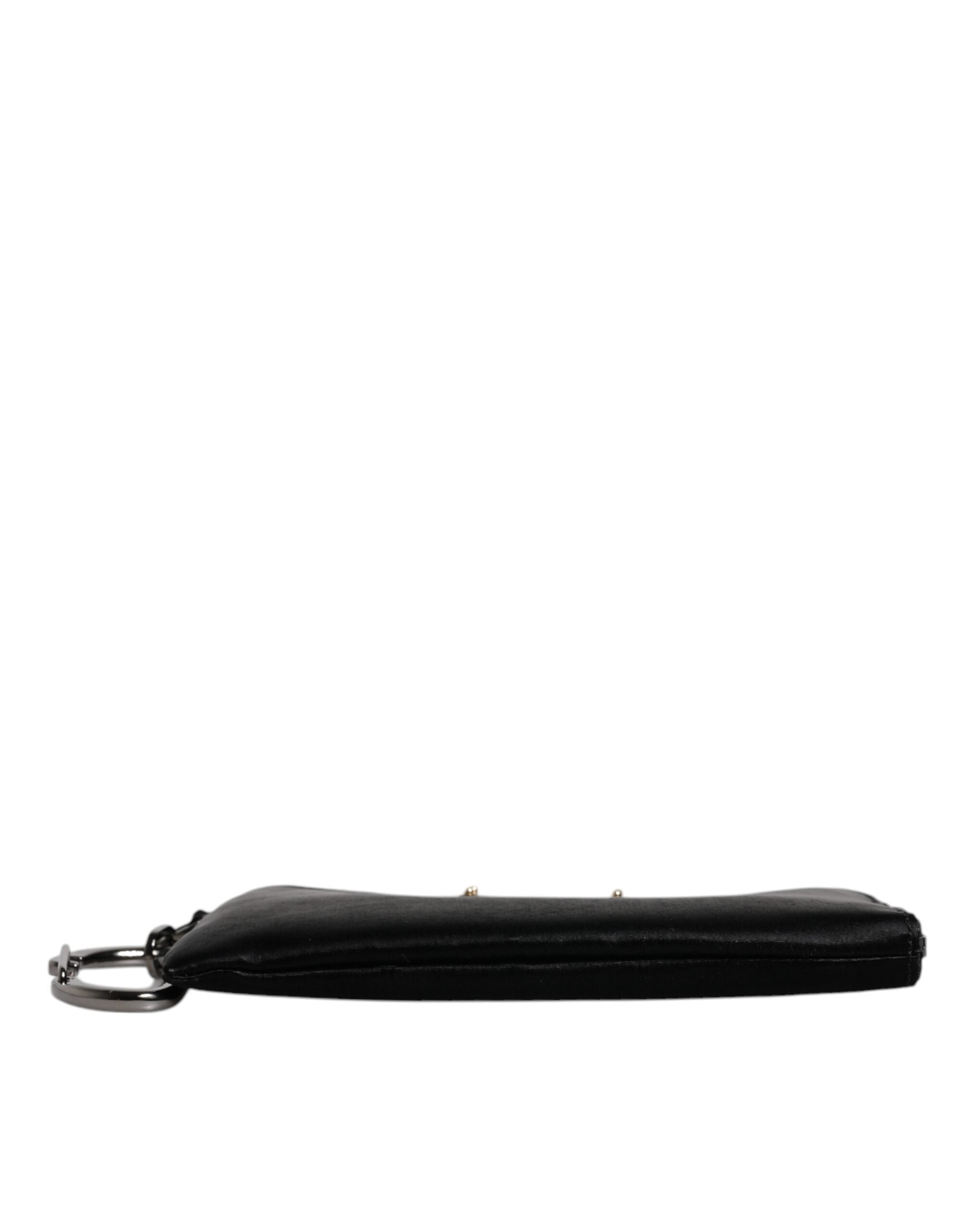 Porte-clés en nylon noir Dolce & Gabbana avec logo en plaque, attaché à une pochette ou clutch élégante.