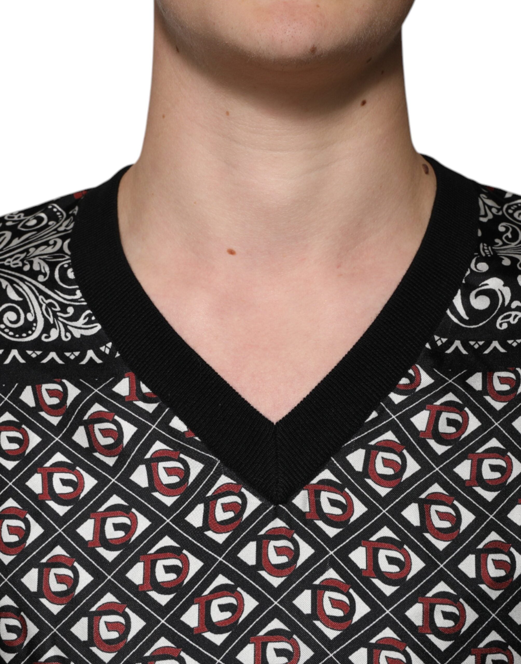 Pull à col en V en laine noire Dolce & Gabbana avec logo, style élégant et moderne, porté sur un mannequin.