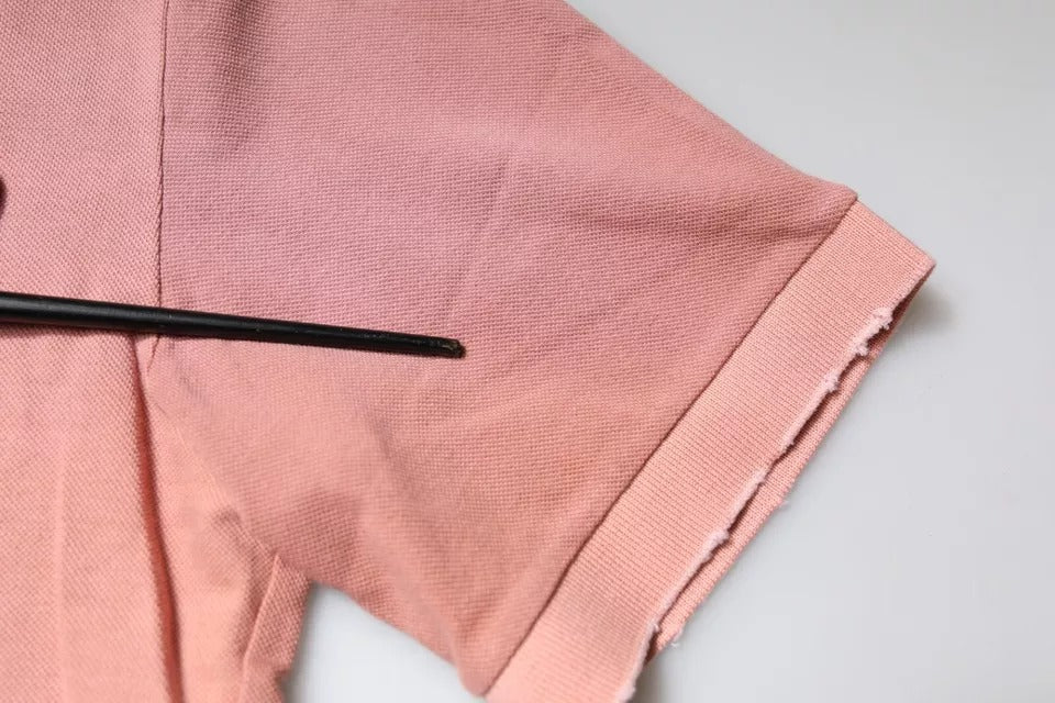 Polo à manches courtes Dolce & Gabbana avec col à revers et motif couronne rose, en tissu léger et élégant.