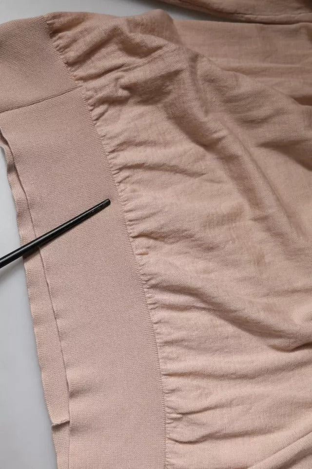 Pull en cachemire beige Dolce & Gabbana, chandail à col roulé élégant avec détails fins, porté en mode décontracté.