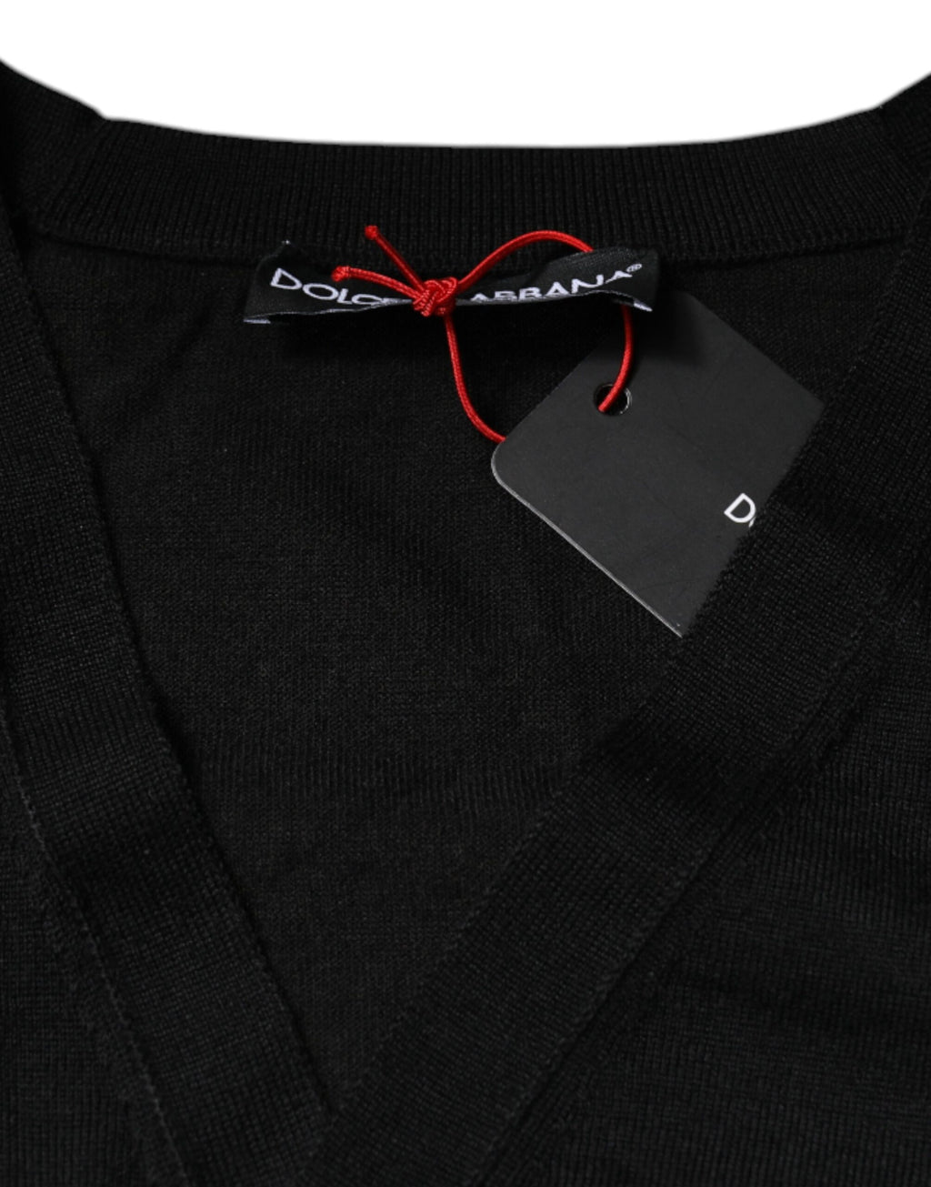 Cardigan noir en cachemire Dolce & Gabbana avec boutons, porté ouvert, détails élégants, tissu doux et chaud.