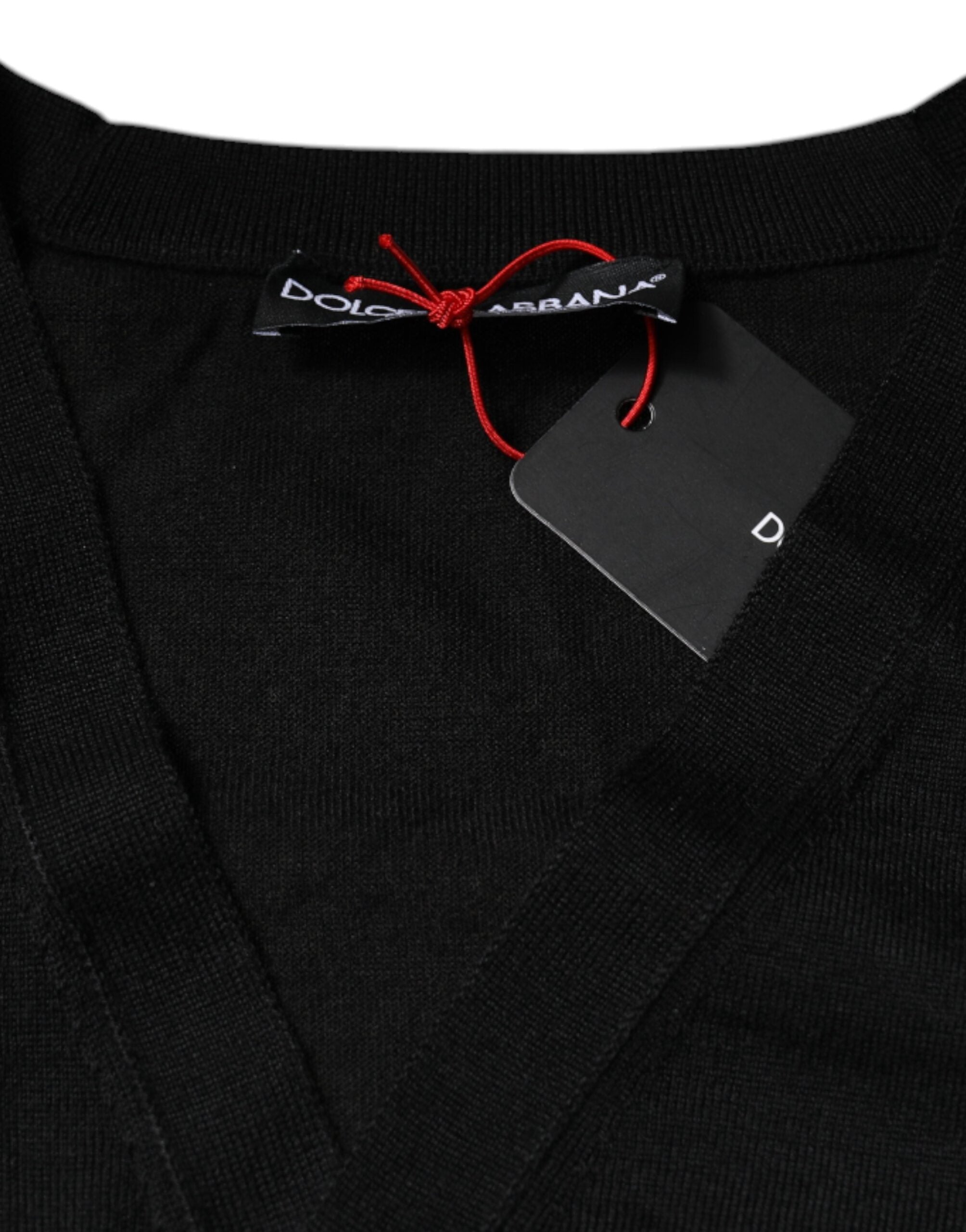 Cardigan noir en cachemire Dolce & Gabbana avec boutons, porté ouvert, détails élégants, tissu doux et chaud.