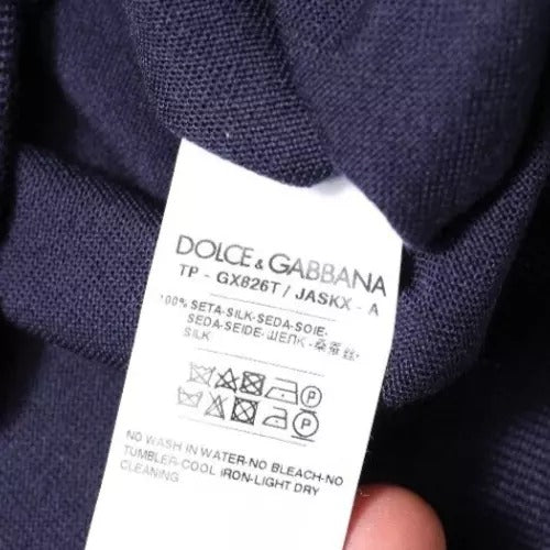 Pull en soie bleu marine Dolce & Gabbana avec col en V, douceur élégante et design raffiné visible sur l'image.