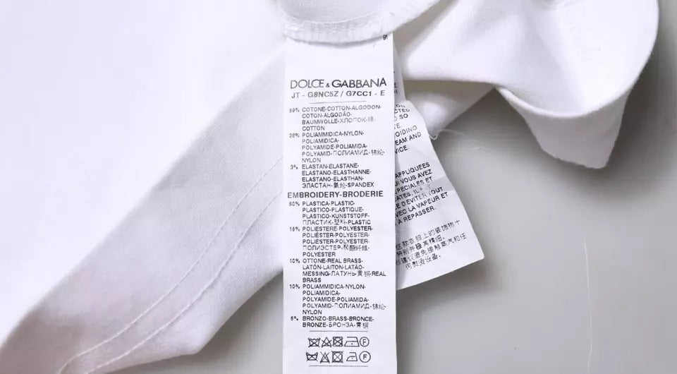T-shirt blanc Dolce & Gabbana à logo orné, col rond, en coton avec détails décoratifs visibles sur l'image.
