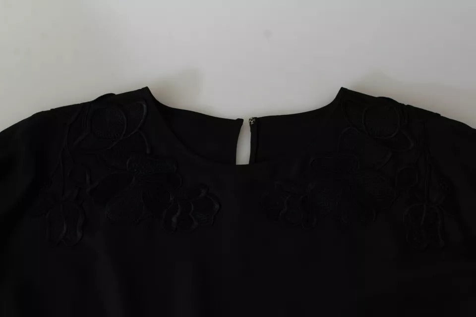 Blouse en soie Dolce & Gabbana noire avec broderie florale élégante, manches longues et détails raffinés.