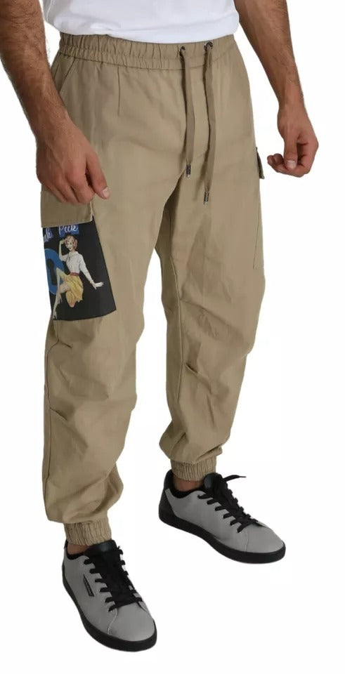 Pantalons cargo beige Dolce & Gabbana à motif pin-up, avec poches et détails stylés, mode chic et décontractée.