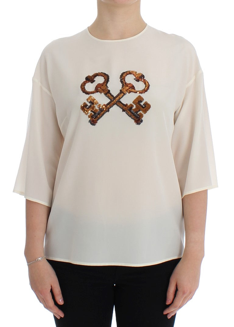 Haut en soie blanc Dolce & Gabbana avec sequins, style blouse ou T-shirt, détails élégants et finition raffinée.