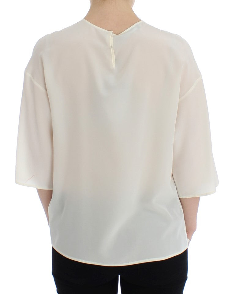 Haut Dolce & Gabbana en soie blanc avec sequins, style blouse ou t-shirt, orné de détails brillants et élégants.
