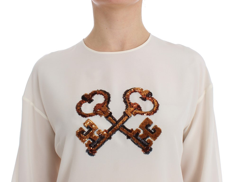 Haut Dolce & Gabbana en soie blanc à sequins, style blouse ou T-shirt, avec détails brillants et élégants.