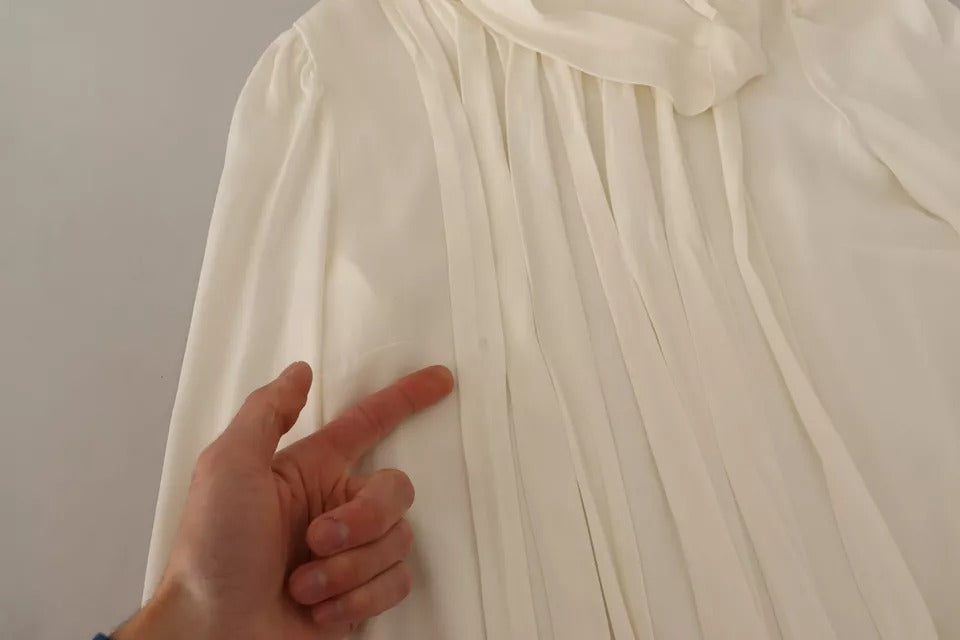 Haut à manches longues en soie blanche de Dolce & Gabbana avec col roulé, élégant et sophistiqué.