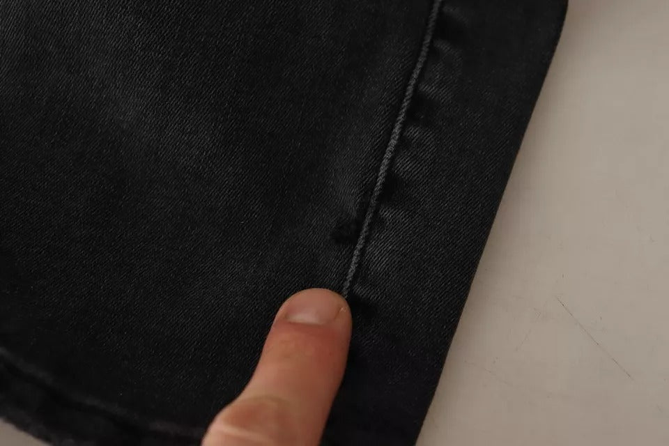 Jeans skinny en denim extensible gris Dolce & Gabbana avec logo, ajustés et confortables, visibles dans l’image.