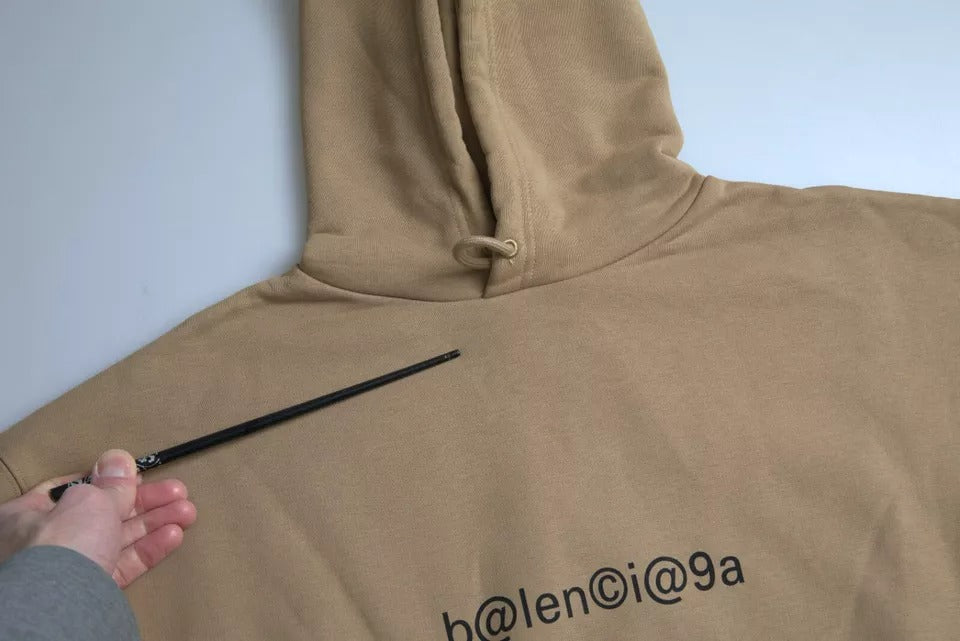 Sweat à capuche molletonné marron Balenciaga avec symbole en bouclette, en coton, tissu doux et confortable.