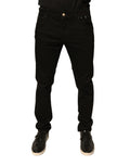 Jean skinny en denim noir Dolce & Gabbana avec logo en coton stretch, ajusté et élégant, visible en détail sur l'image.