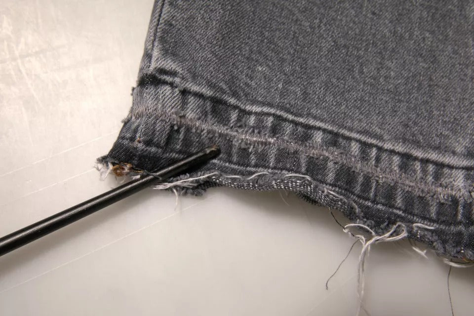 Jeans skinny en denim gris avec logo en coton stretch de Dolce & Gabbana, visibles avec détails de la couture et de la fermeture éclair.