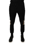 Pantalon jogger slim fit noir à motif léopard de Dolce & Gabbana, vue de face avec détails de la couture et de la taille.