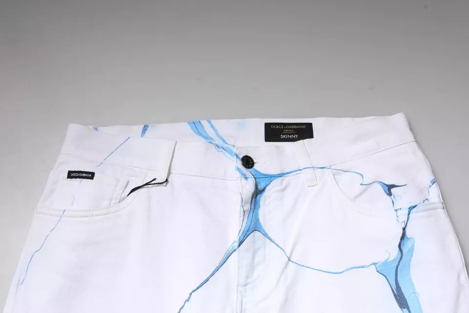 Jeans skinny en denim blanc et bleu en coton stretch de Dolce & Gabbana, visibles dans l'image.
