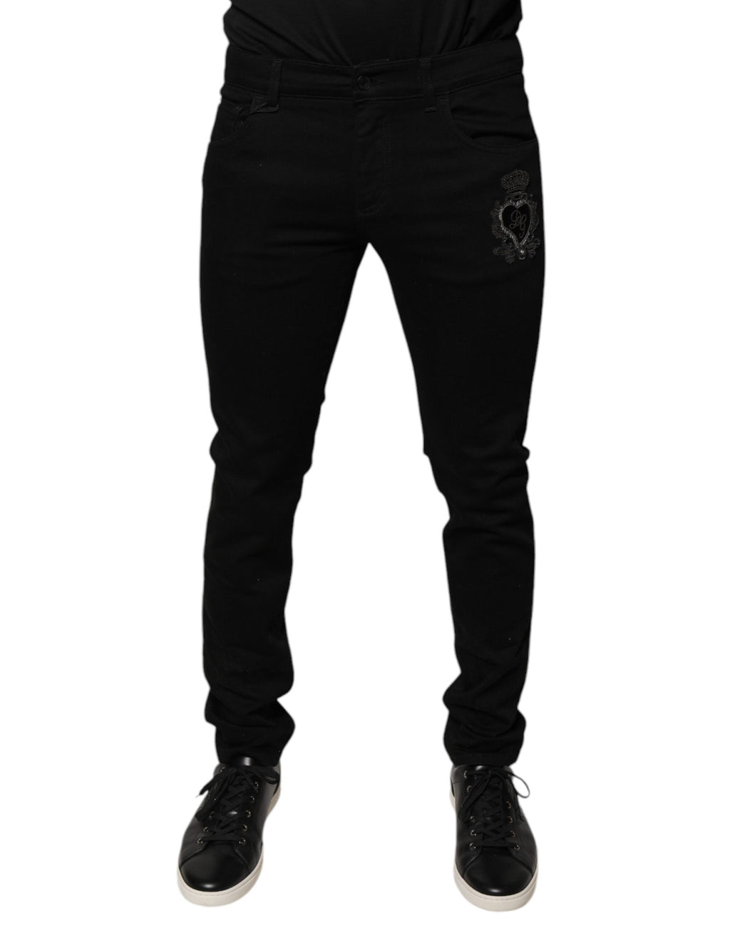 Jeans skinny en denim coton noir Dolce & Gabbana avec logo couronne DG, visible sur le devant.
